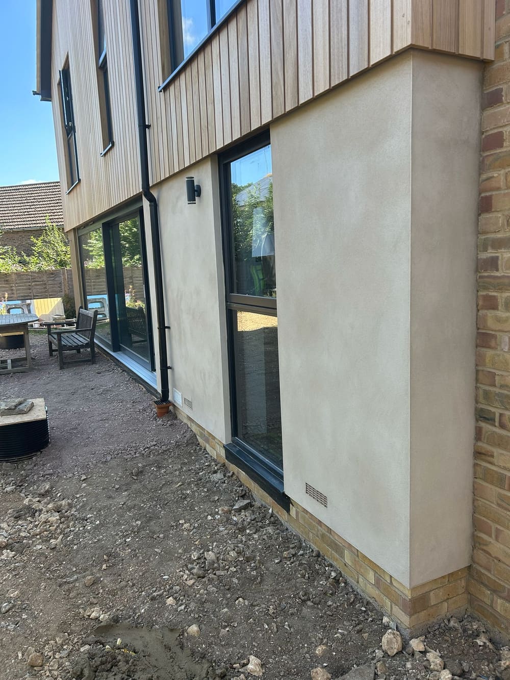 Freshly rendered modern extension with timber cladding in West Sussex