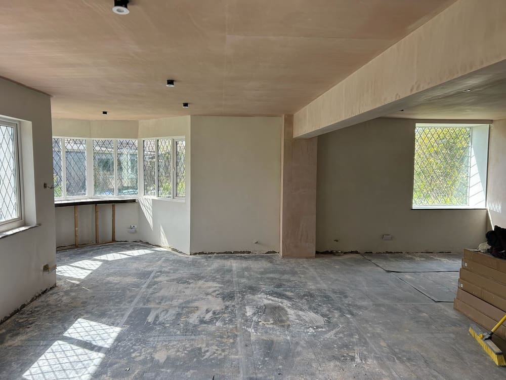 Large open-plan room freshly plastered throughout, walls and ceiling ready for finishing